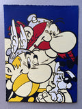 Three comic characters – Asterix with yellow moustache, Obelix with red hair and the white haired Dogmatix – have a happy hug on a blue background