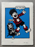 Dennis the menace from the beano and his dog gnasher are laughing at something and hold their stomachs in hilarity; he is dressed in a red and black striped football kit