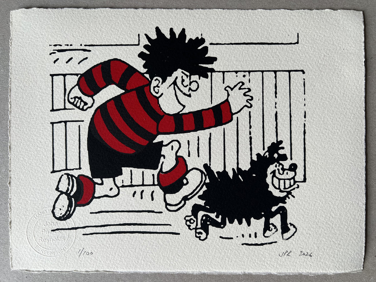 Dennis in his red and black football jersey runs in front of a fence, with gnasher by his side