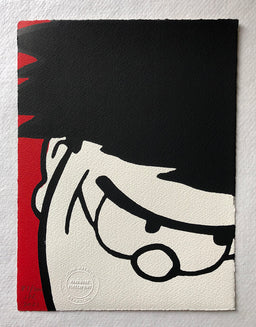 Dennis menace cracks a sly grin, in closeup. With a red background. From the beano comic