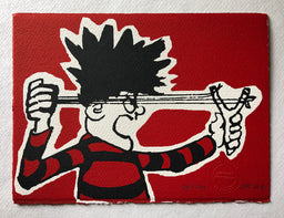 dennis menace from the beano comic in red and black jersey fires his catapult on a red background. 