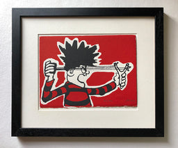 dennis menace from the beano comic in red and black jersey fires his catapult on a red background. 